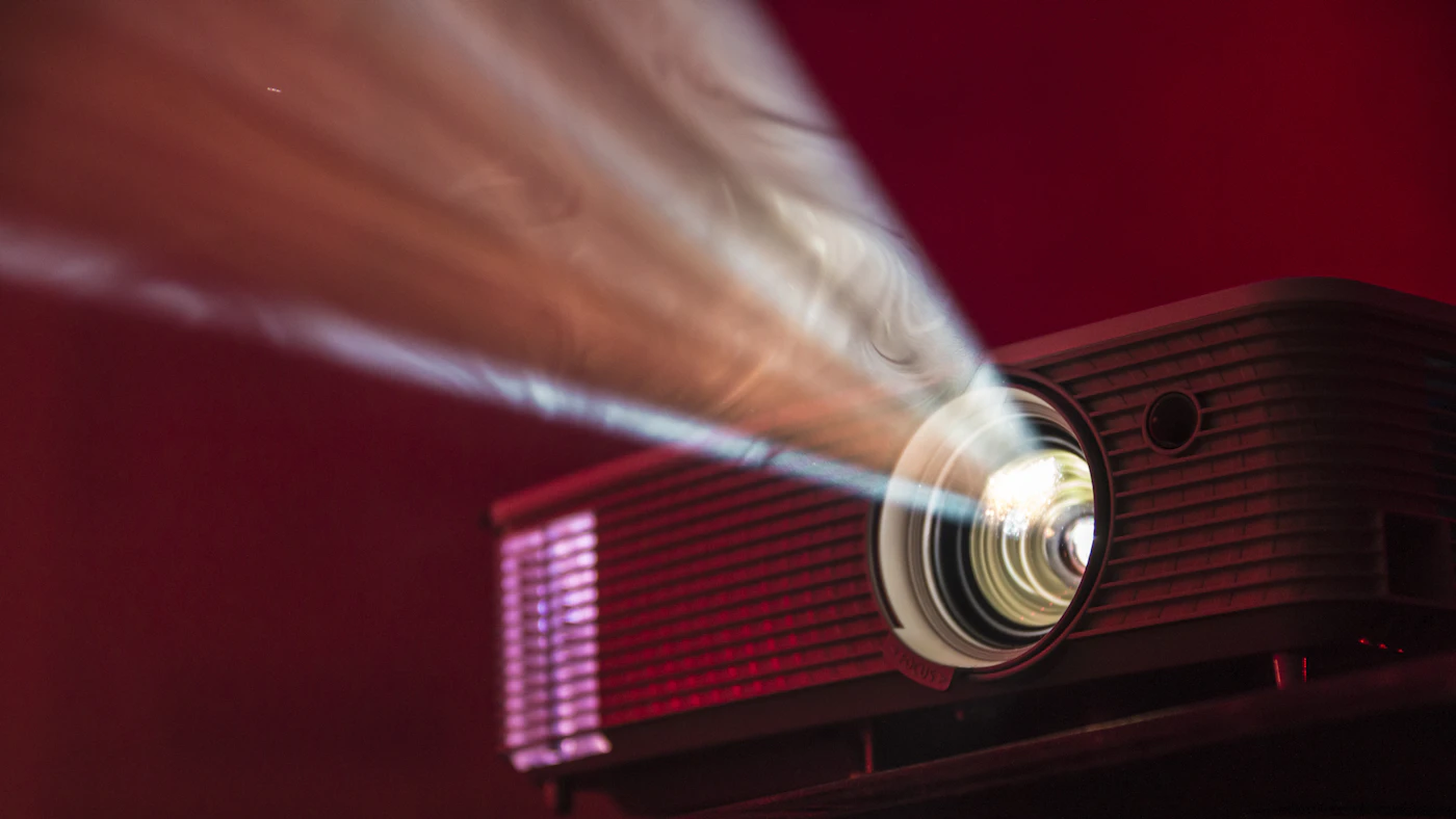 Close-up of a red projector lens beaming light