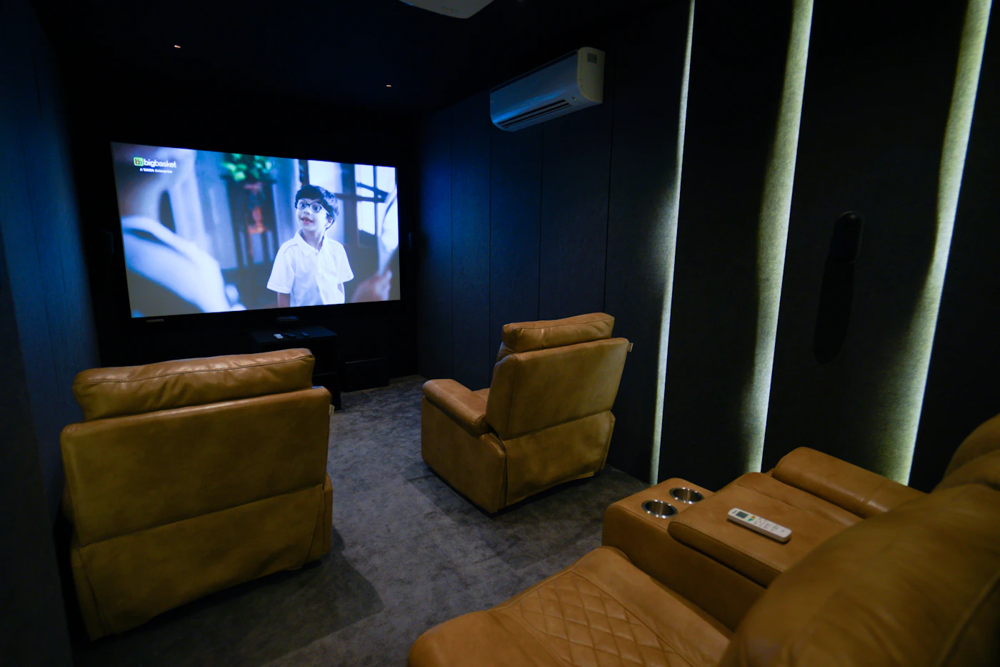Home theater room with two leather recliners facing a large screen